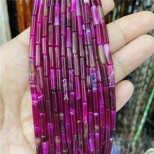 Macro detail of rose red cylindrical agate beads with natural semi-transparent textures