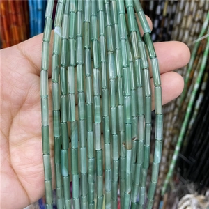 Macro shot of 3x12mm green cylindrical agate beads for DIY jewelry making