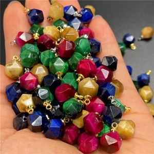 Macro shot of colorful faceted tiger eye pendants being held in hand for DIY jewelry
