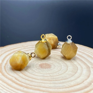 Macro view of faceted tiger eye stone pendants with gold and silver metal connectors