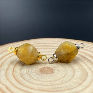 Macro detail of faceted tiger eye gemstone connectors with gold and silver loops