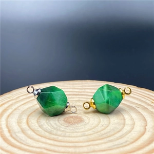 Macro shot of faceted green tiger eye stone connectors in gold and silver plating
