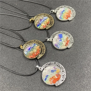 Detailed view of crescent moon pendants featuring colorful natural chakra stones and filigree