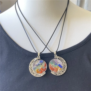 Detail of crescent moon pendants with colorful natural stones and ornate filigree edges
