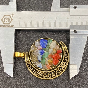 Detailed measurement of the sun and moon pendant showing its width of 4.4 cm on a caliper