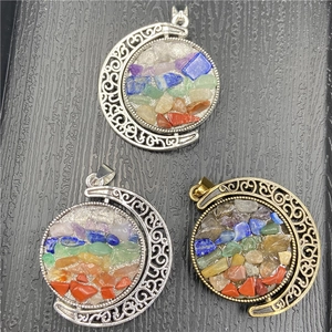Detail of crescent moon pendants with hollow scroll patterns and colorful chakra crystals