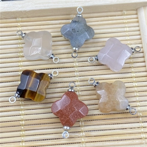 Macro view of faceted natural stone four-leaf clover connectors with silver loops