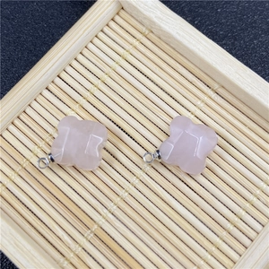 Detailed view of faceted pink quartz flower charms with silver metal pendant loops
