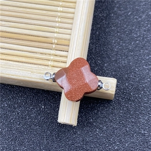 Detailed view of a four-leaf clover brown sandstone connector with silver metal loops