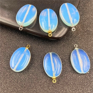 Macro detail van ovale opaalsteen hangers met goud en zilveren lussen voor DIY sieraden