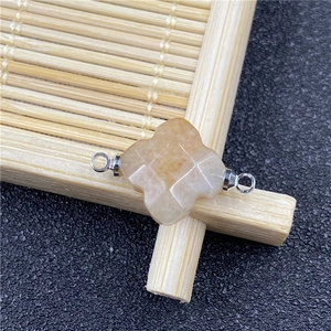 Macro view of light yellow quartz clover flower connector with silver metal loops