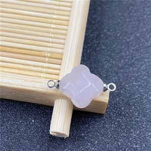 Close-up of rose quartz quatrefoil flower connector with faceted gemstone and silver rings
