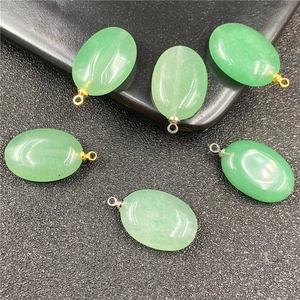Detailopname van ovale groene agaat hangers met goud- en zilverkleurige oogjes