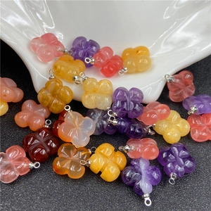 Close-up of assorted amethyst and quartz four-leaf clover pendants with silver bails