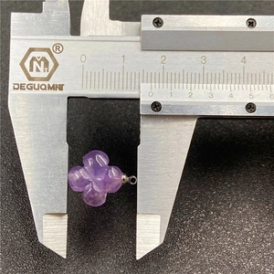 Macro shot showing purple amethyst four-leaf flower pendant size being measured with calipers