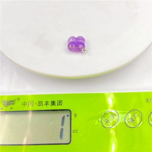 Detailed view of a purple amethyst clover pendant weighing 1 gram on a digital scale
