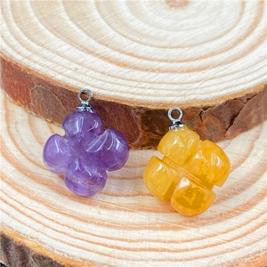 Detail of amethyst clover pendant with natural texture on a light wood background