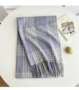 Detail of purple and white plaid scarf with long fringe on a white table