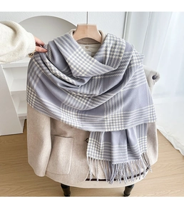 Detail of light purple plaid scarf with fringe edges draped on a beige winter coat