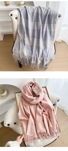 Detail view of plaid scarf textures in grey and pink with soft fringe edges