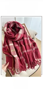Detail of soft cashmere-like plaid scarf featuring classic fringe and red check pattern