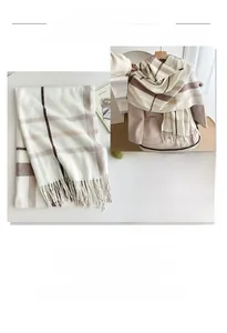 Detail view showing textured plaid pattern and tassel fringe of the thick winter scarf