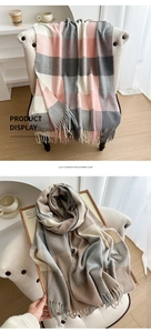 Detail of soft plaid scarves with fringe in pink, grey and beige cashmere-like texture