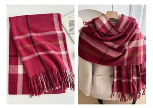 Detail of red and pink plaid scarf with fringe texture and styling on light wool coat