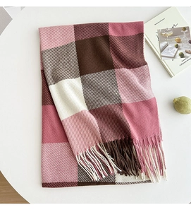 Detail of soft knit texture and tassels on pink and brown plaid checkered scarf