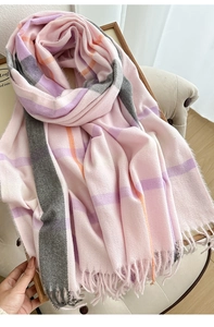 Detailed close-up of pink and grey plaid scarf with tassels and soft cashmere texture