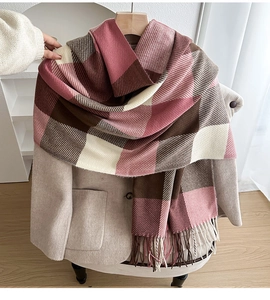 Close-up of pink and brown plaid scarf texture with soft fringe and autumn styling