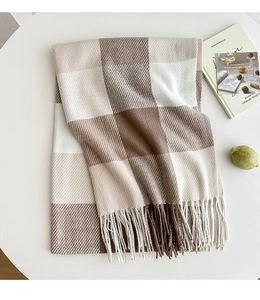 Detailed view of the thick brown and beige checkered scarf with long fringe on a table