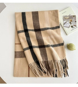 Close-up of beige plaid scarf with thick tassels and soft cashmere-like fabric texture