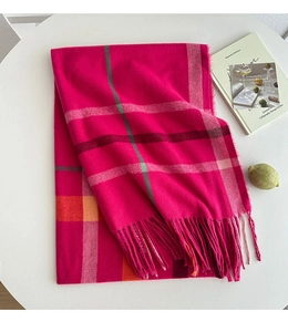 Close-up of pink plaid tassel scarf texture with autumn-winter fringe details