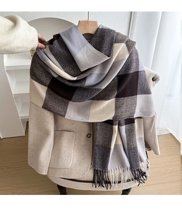 Close-up of thick checkered plaid scarf with soft fringe on a neutral coat