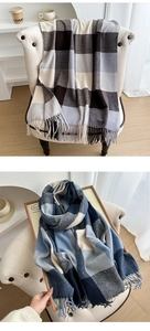 Detail of soft checkered scarf with tassels in warm brown and cool blue tones