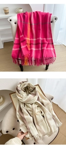 Detailed view of winter plaid scarves with rose red and beige patterns and long tassels