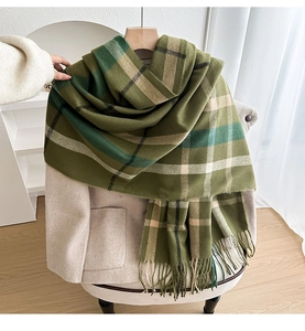 Detail of green plaid scarf with soft tassels hanging on a hanger for winter warmth