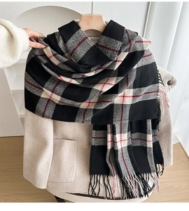 Close-up of classic black and beige plaid scarf with fringe and red stripe detail