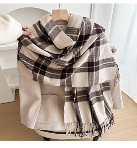 Detail showing the classic plaid scarf texture and fringe on a beige woolen coat