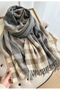 Detailed view of grey and brown plaid scarf featuring soft fringe edges and thick texture
