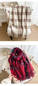 Close-up of thick plaid scarves with soft fringe details in beige and red patterns