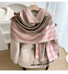 Detail of soft plaid scarf with tassels, featuring pink and beige color block design