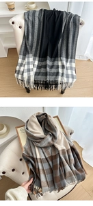 Detail shot of soft plaid scarves with fringe in grey, black, and warm brown tones