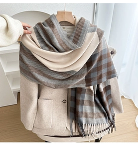 Detail of checkered tassel scarf showing thick knit texture and fringe on wool coat