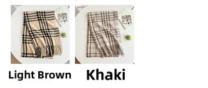 Detail of plaid scarves in light brown and khaki with soft fringe on a minimalist desk