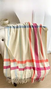Detail shot of the thick plaid scarf with soft fringe edges and colorful check pattern