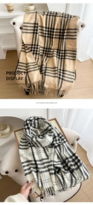Detail of plaid scarf featuring long fringe tassels and soft cashmere-like texture