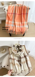 Detailed view of imitation cashmere plaid scarves in orange and beige with fringe