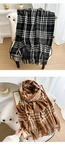 Detailed view of checkered plaid scarves with long fringes in black and brown tones